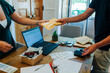 © Alexandra C. Ribeiro/Westend61 - Young male and female colleagues holding package while standing office