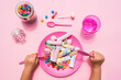 © gemma ferrando & jeremie roman/Westend61 - Hands of baby girl preparing to eat plate filled with various sweets