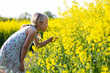 © Jana Fernow/Westend61 - Little girl taking smell of rapeseed flowers while standing in field
