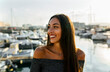 © Marco Govel/Westend61 - Beautiful woman smiling while standing at harbor during sunset