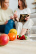 © Manu Reyes
www.vientocuatro.com/Westend61 - Fruits kept on table with women in background discussing about nutrition at home