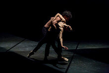 Male And Femal Dancer Performing Contemporary Ballet On Black Stage