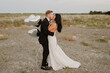 © Sara Monika/Westend61 - Smiling groom with heart shape balloons kissing bride against sky