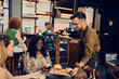 © Dangubic/Westend61 - Waiter serving hamburger for woman in a pub
