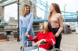 © William Perugini/Westend61 - Young women spending leisure time with disabled female friend in city during weekend, London, UK