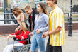 © William Perugini/Westend61 - Happy men and women with disabled female friend spending leisure time in city