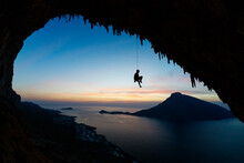 Rock Climber Moving Down From Rock At Dusk