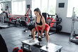 © WellStock - Woman standing on steps and doing squats with kettlebell