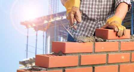 Wall Mural - Man worker installing brick masonry wall with a trowel