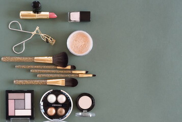 Makeup professional decorative cosmetics on green background top view.Copy space