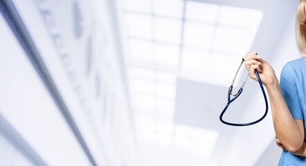 Young man doctor holding stethoscope on background