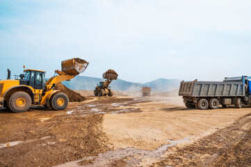 Wall Mural - Wheel loader loads clay into the bucket of a dump truck