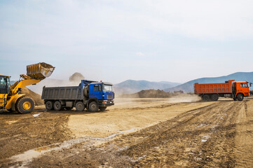 Wall Mural - Wheel loader loads clay into the bucket of a dump truck