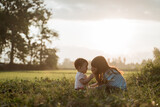 Fototapeta Kuchnia - older sister plays with her younger sister in the fields on sunset