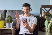 Teenager Boy In Headphones With Smartphone Making Video Call