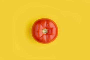 One ripe juicy red fresh tomato on a yellow background. Farm vegetables natural eco bio. Minimalism pattern trendy background. Place for text copy space top view. minimalism pattern poster