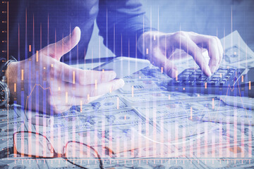 Double exposure of man's hands holding and using a digital device and forex graph drawing. Financial market concept.