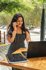 A young beautiful woman works at her laptop in a modern office space