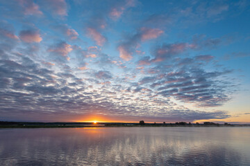 Wall Mural - sunrise, sunset over the river crept a small fog over the water, beautiful colorful clouds.