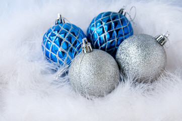 New year's still life: two blue and two silver Christmas balls on a white Swan's down for a postcard