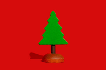 Christmas composition. Green wooden herringbone on a red background. Side view, place for text.