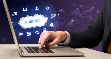 businessman working on laptop with robotics inscription, modern technology concept