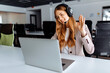 © Shopping King Louie - Smiling young female operator in headphones with headset working with laptop sitting at table at workplace, technical support concept