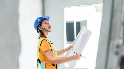 woman architect is checking the house being built to match the design.