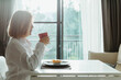 © Kannapat - Asian woman drink coffee while take breakfast.