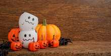 Close Up Group Of Orange Spooky Pumpkins And Ghost Basket Lay And Spider On Brown Retro Wood Tabletop Background For Design In Halloween Celebration Collection Concept	
