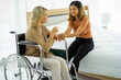 © ake - caucasian senior patient recover woman on wheelchair and mixed race daughter in hospital room new normal.