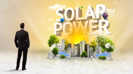 Rear view of a businessman standing in front of SOLAR POWER inscription, Environmental protection concept