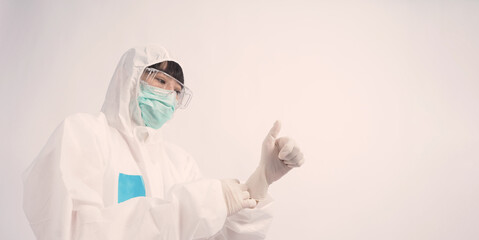 Southeast asia woman doctor in PPE suit or Personal Protective Equipment uniform and wearing medical face mask, rubber gloves and goggles for protect coronavirus pandemic. Studio shot with copy space.