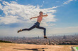© Lorea - Mujer saltando y haciendo deporte con la ciudad de fondo