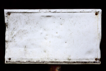 An old rusty, weathered white sign against a dark background, with space for text