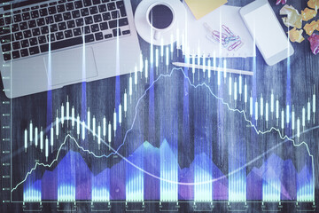 Financial market graph and top view computer on the desktop background. Double exposure. Investment concept.