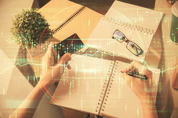 Multi exposure of woman on-line shopping holding a credit card and financial graph drawing. Stock market E-commerce concept.