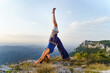 © Miljan Živković - Young attractive woman standing on the top of the mountain in yoga pose practicing in sunny summer or autumn day - relaxation and meditation concept front view full length copy space