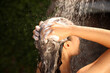 © New Africa - Woman washing hair in outdoor shower on summer day, closeup