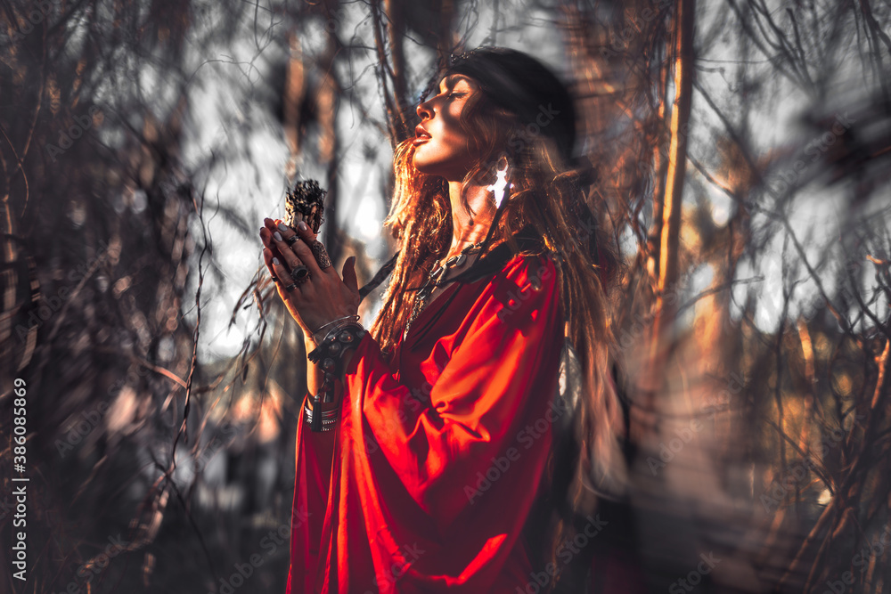 beautiful young woman with shamanic fire outdoors - obrazy, fototapety, plakaty 