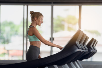 Wall Mural - Sports woman is working out in gym, doing cardio training on treadmill, Running in run equipment, healthy lifestyle