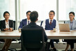 © imtmphoto - young asian businessperson being interviewed by a group of business people
