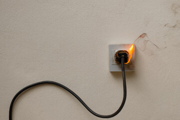 On fire electric wire plug Receptacle on the concrete wall background