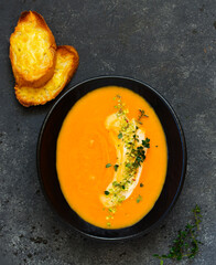 Canvas Print - Pumpkin soup on a gray background. Selective focus.