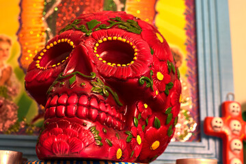 Wall Mural - Mexican day of the dead skull with red and green daisies and red teeth, with small red candles