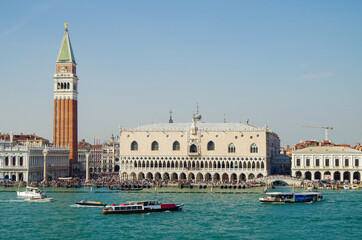 Panoramic scenic view of Venice Venezia skyline with bell towers, old historic buildings palazzi houses, basilica churches and San Marco tower and Doge palace and maritime traffic on Giudecca Canale