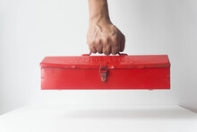 Hand Holding Red Mechanic Toolbox On White Background.