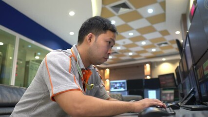Inside the large Industry Factory male Computer Engineer Works on Personal Computer he coding program for control machine,Thailand people work on fours monitors,Programmer working with serious