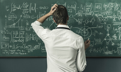Mathematician solving problems and writing formulas on the chalkboard