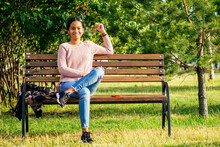 Vietnamese Woman In Pink Sweater Sitting On The Bench